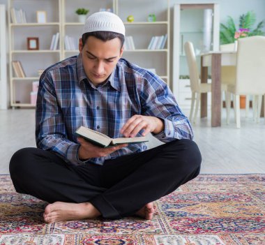 Genç Müslüman adam evde dua ediyor.