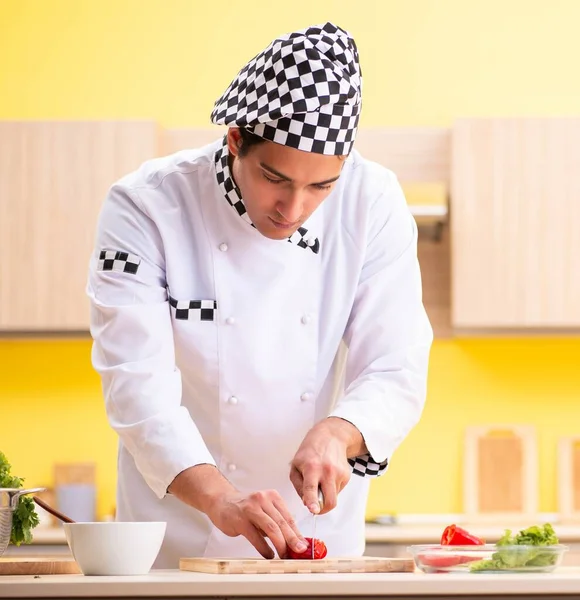 Young professional cook preparing salad at home — Stock Photo, Image