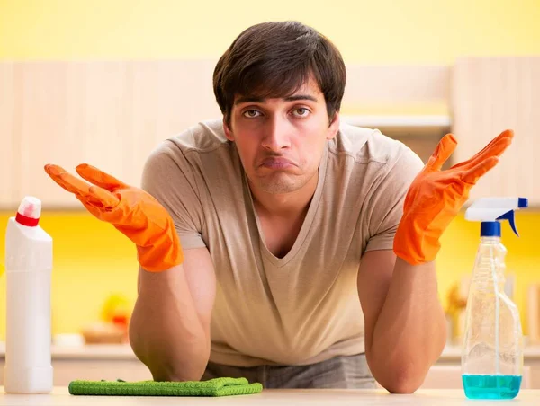 Single man cleaning kitchen at home