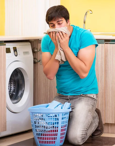 Jonge man doet de was thuis — Stockfoto