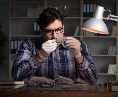 Arkeolog geç saatlere kadar ofiste çalışıyor.