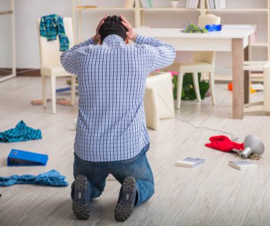 Hırsızlar tarafından soyulduktan sonra evini bulan bir adam.