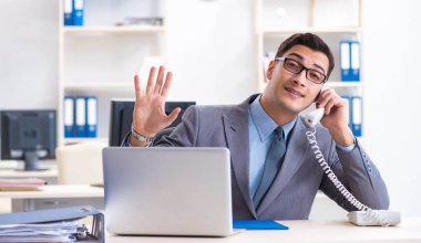 Ofisteki masasında oturan yakışıklı bir işadamı.