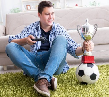 Genç adam evde bilgisayar oyunu oynuyor.