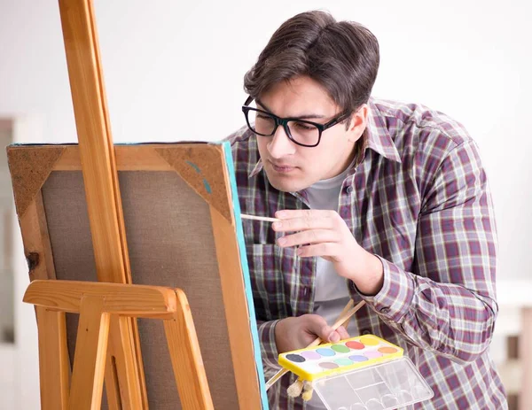 Jovem artista masculino desenho de imagens em estúdio brilhante — Fotografia de Stock