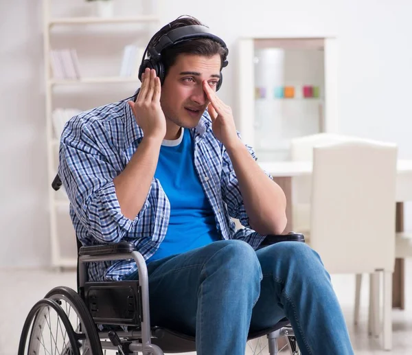 Hombre discapacitado escuchando música en silla de ruedas —  Fotos de Stock