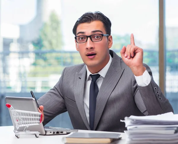 Empresario con carrito de compras en oficina — Foto de Stock