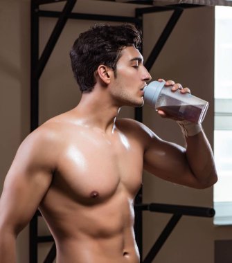 Spor salonunda besin takviyesi olan bir adam.