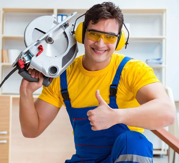 Reparador carpintero cortando aserrar una tabla de madera con un circuito —  Fotos de Stock