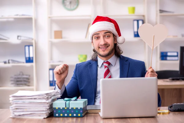 Νεαρός υπάλληλος που εργάζεται στο γραφείο την παραμονή των Χριστουγέννων — Φωτογραφία Αρχείου