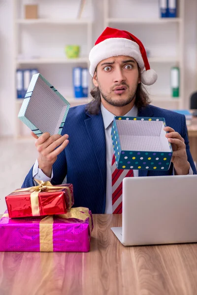 Jovem funcionário do sexo masculino que trabalha no escritório na véspera de Natal — Fotografia de Stock