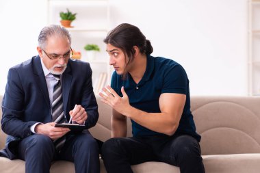 Genç adam yaşlı erkek psikoloğu ziyaret ediyor.