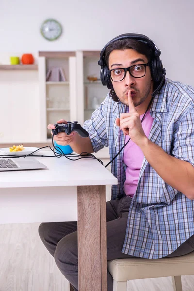 Jovem estudante do sexo masculino jogando jogos de computador em casa — Fotografia de Stock