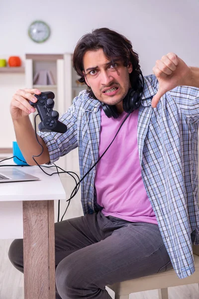 Ung manlig student spelar dataspel hemma — Stockfoto