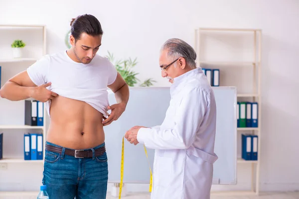 Médico dietista dando consejos a pacientes con sobrepeso de grasa — Foto de Stock