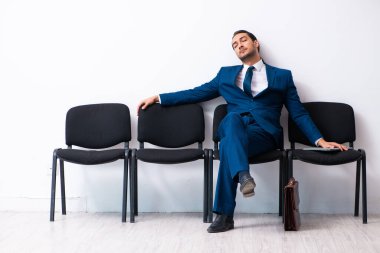 Genç işadamı salonda röportaj için bekliyor.