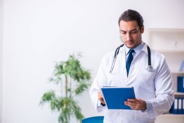 Klinikte çalışan yakışıklı genç bir doktor.