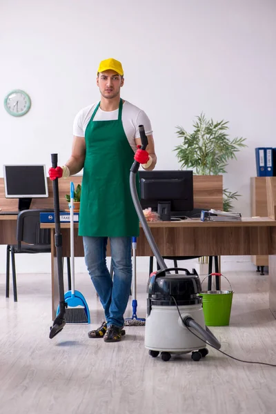 Jovem empreiteiro limpando o escritório — Fotografia de Stock