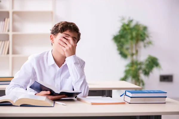 Skolpojke förbereder sig för tentor i klassrummet — Stockfoto