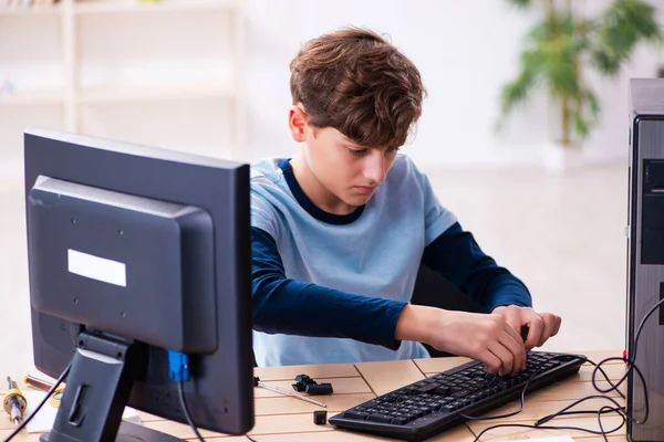 Chlapec opravuje počítače v dílně — Stock fotografie