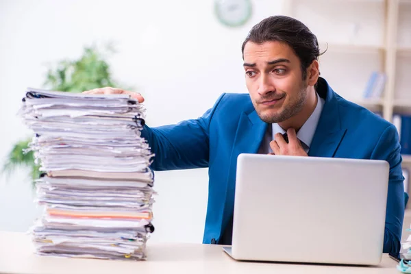 Giovane dipendente maschio infelice con il lavoro eccessivo — Foto Stock