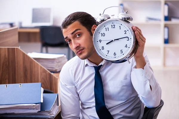 Jonge mannelijke werknemer ongelukkig met overmatig werk in het kantoor — Stockfoto