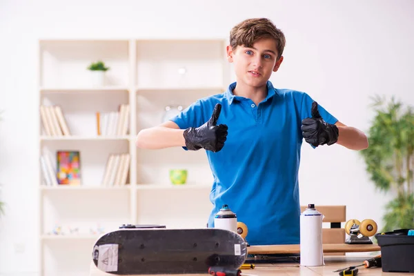 Ragazzo che ripara skateboard a casa — Foto Stock