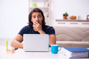 Evden çalışan genç bir adam.