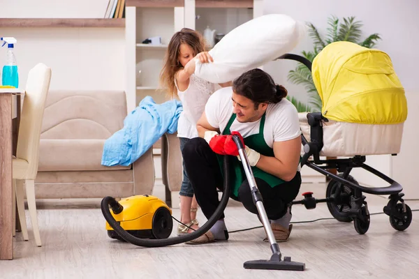 Joven contratista masculino limpiando la casa con su hija pequeña — Foto de Stock