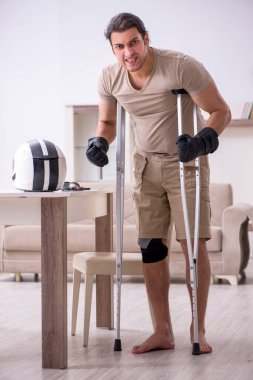 Kazadan sonra evde acı çeken genç bir motosikletçi.