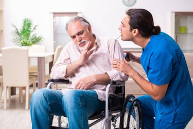 Tekerlekli sandalyedeki yaşlı adam ve genç kötü bakıcı.