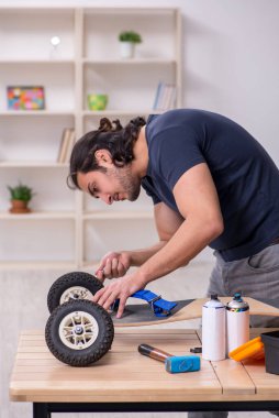Kaykay tamir eden genç bir erkek tamirci.
