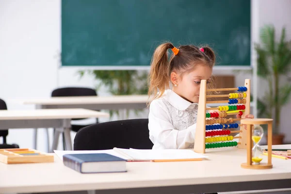 Kleines Mädchen mit Abakus im Klassenzimmer — Stockfoto