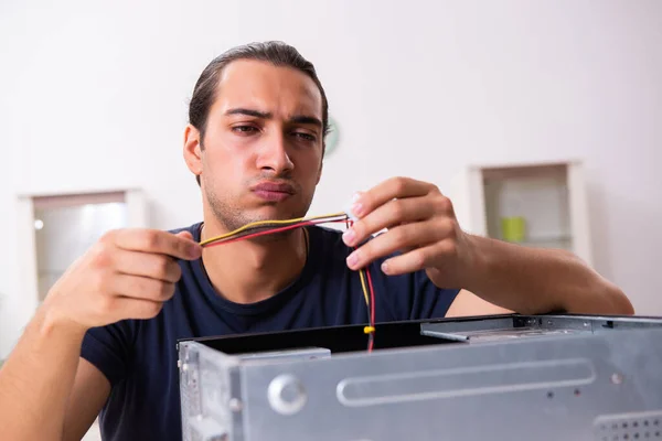 Genç adam evde bilgisayar tamir ediyor. — Stok fotoğraf