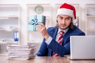 Noel arifesinde ofiste çalışan genç bir erkek işçi.