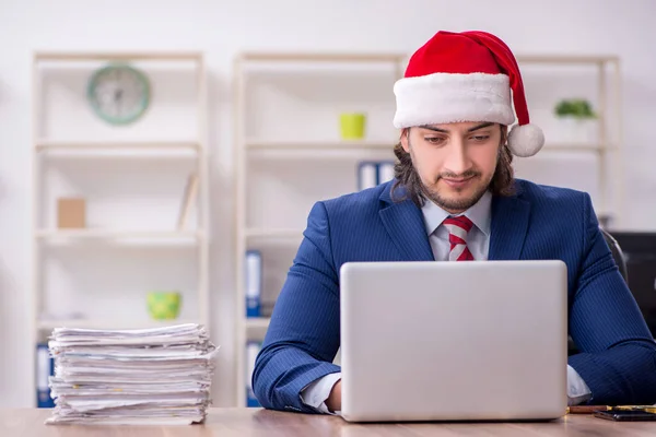 Joven empleado masculino que trabaja en la oficina en Nochebuena — Foto de Stock