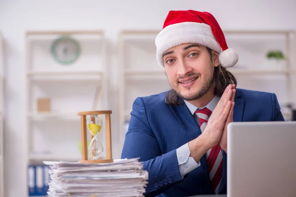 Joven empleado masculino que trabaja en la oficina en Nochebuena —  Fotos de Stock