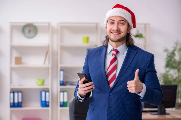 Jonge mannelijke werknemer werkt in het kantoor op kerstavond — Stockfoto