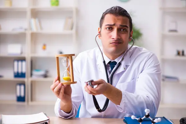 Jovem médico do sexo masculino no conceito de gestão do tempo — Fotografia de Stock