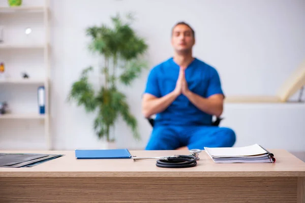 Young male doctor being extremely tired after night shift — Stock Photo, Image