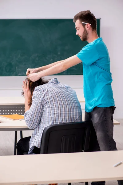 Twee mannelijke leerlingen in het pestconcept in de klas — Stockfoto