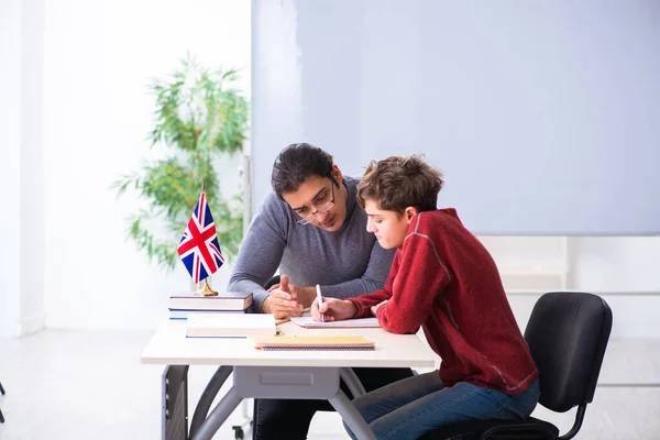 Jonge mannelijke leraar en schooljongen in de klas — Stockfoto