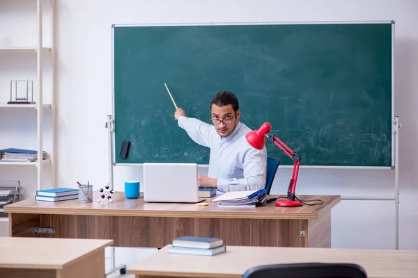 Jonge mannelijke leraar in de voorkant van groene boord — Stockfoto