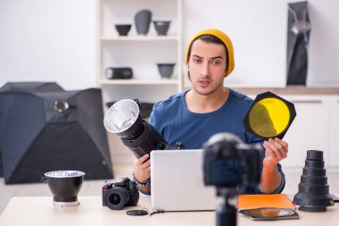 Genç erkek fotoğrafçı bloğu için video kaydediyor.