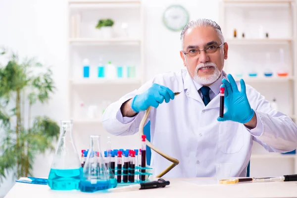 Alter Chemiker mit Schlange im Wissenschaftslabor — Stockfoto