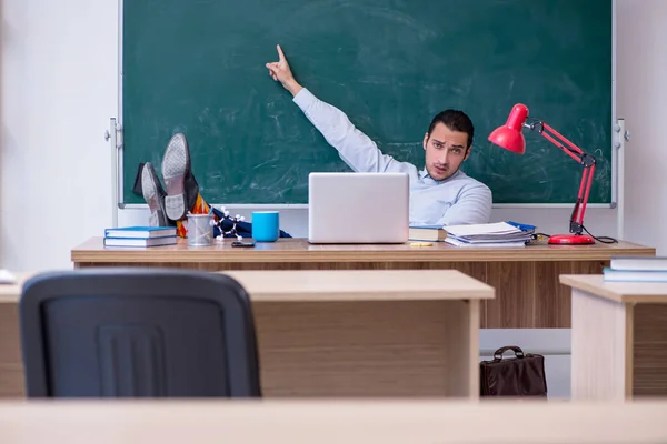 Jonge mannelijke leraar in de voorkant van groene boord — Stockfoto