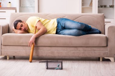 Genç adam ve fare kapanı evde.