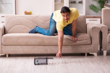 Genç adam ve fare kapanı evde.