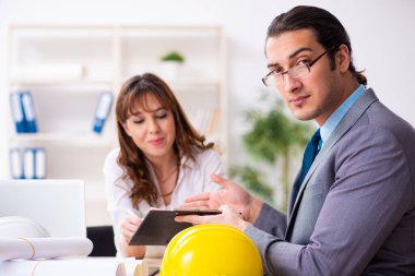 Genç işadamı ve bayan mimar yeni projeyi tartışıyor