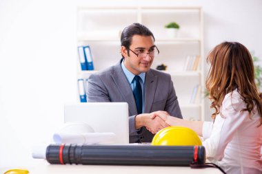 Genç işadamı ve bayan mimar yeni projeyi tartışıyor